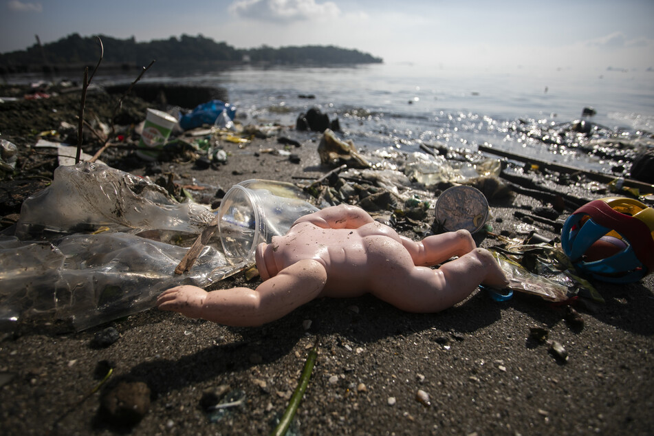 Eine weggeworfene Puppe liegt inmitten von Müll an der Küste der Guanabara-Bucht in Rio de Janeiro.