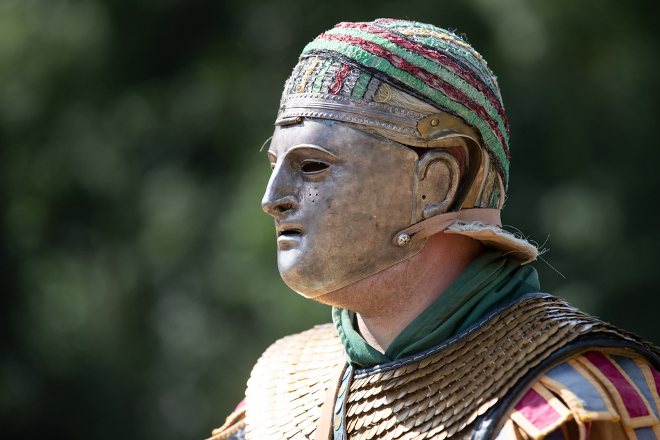 Ein Römerdarsteller reitet mit einer Maske im Museum und Park Kalkriese. (Symbolbild)