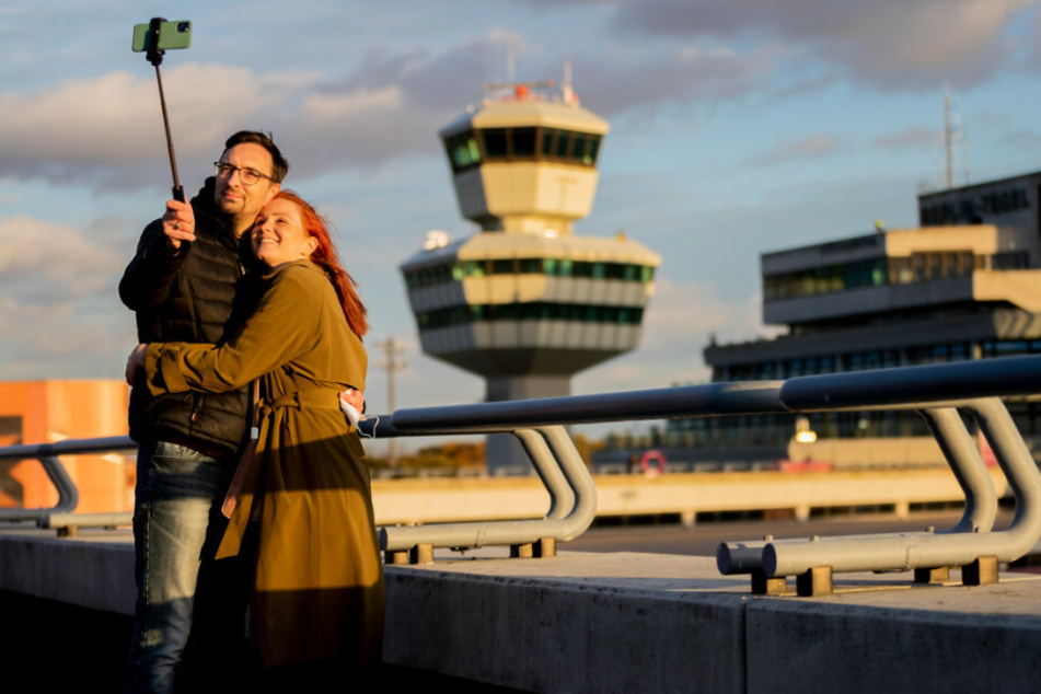 Sarah und Ronny nehmen bei einem Abschiedsbesuch am Flughafen Berlin-Tegel auf der Besucherterrasse vor dem Tower ein Selfie auf.