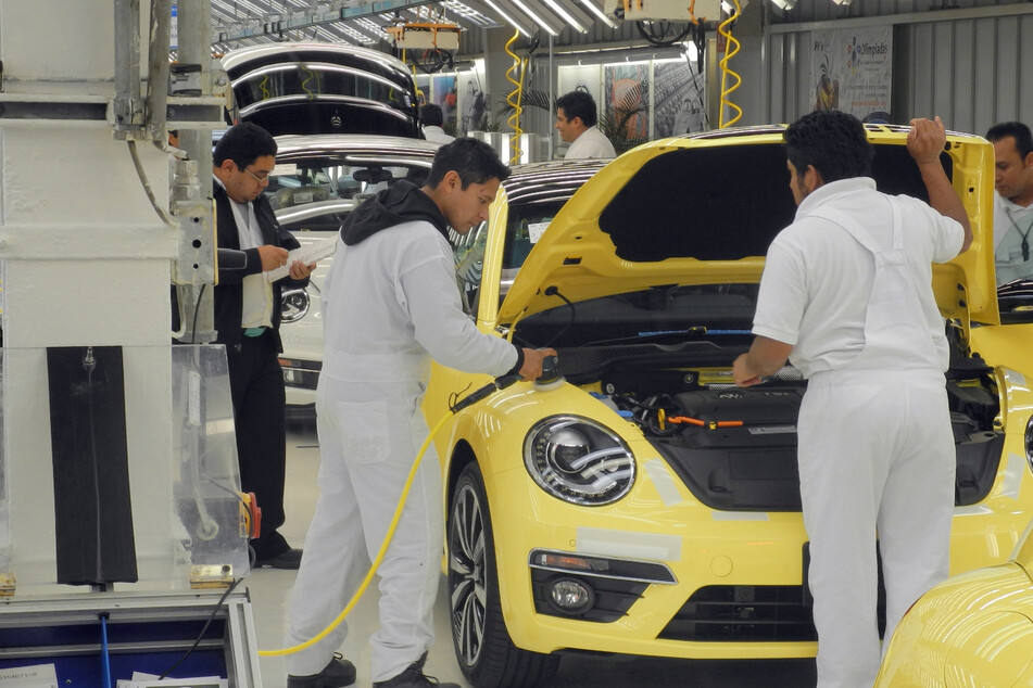 Mitarbeiter eines VW-Werks montieren am einen Beetle. (Archivbild)