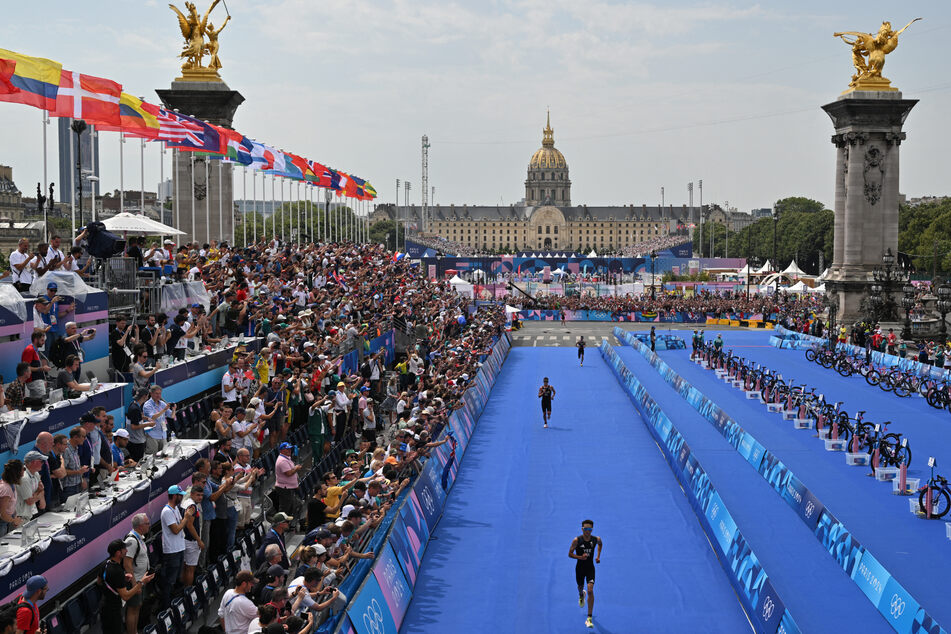 Britain's Alex Yee runs toward the finish line to win the running stage during the men's individual triathlon at the Paris Olympic Games on Wednesday.