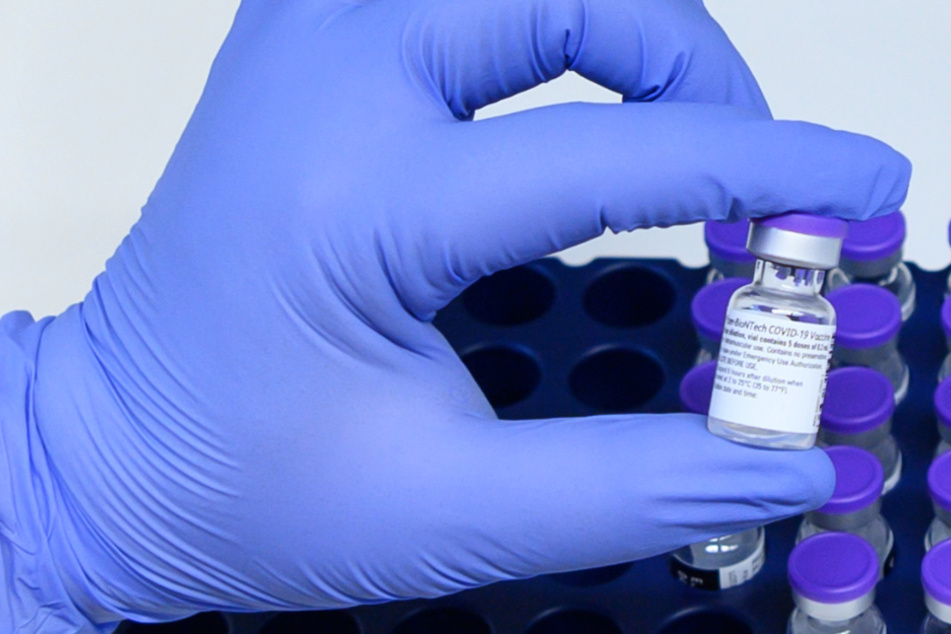 Eine Klinik-Mitarbeiterin nimmt ein Injektionsfläschchen mit Corona-Impfstoff aus einem Kühlschrank.