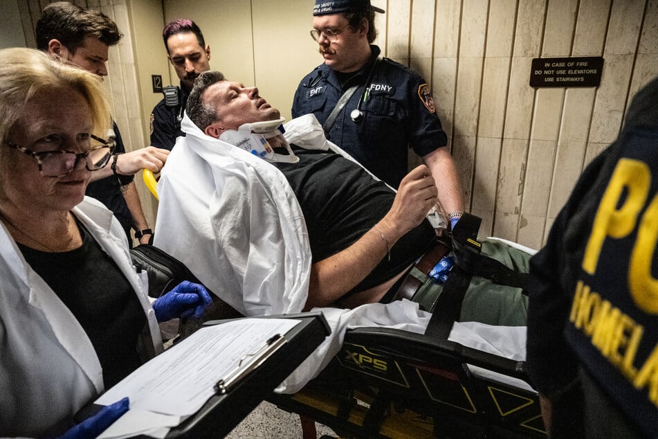 EMS places L. Vural Elibol, a chief cameraman and videographer for the Anadolu Agency, onto a stretcher after he was thrown to the ground and injured by federal agents at the Jacob K. Javits federal courthouse in New York City on September 30, 2025.