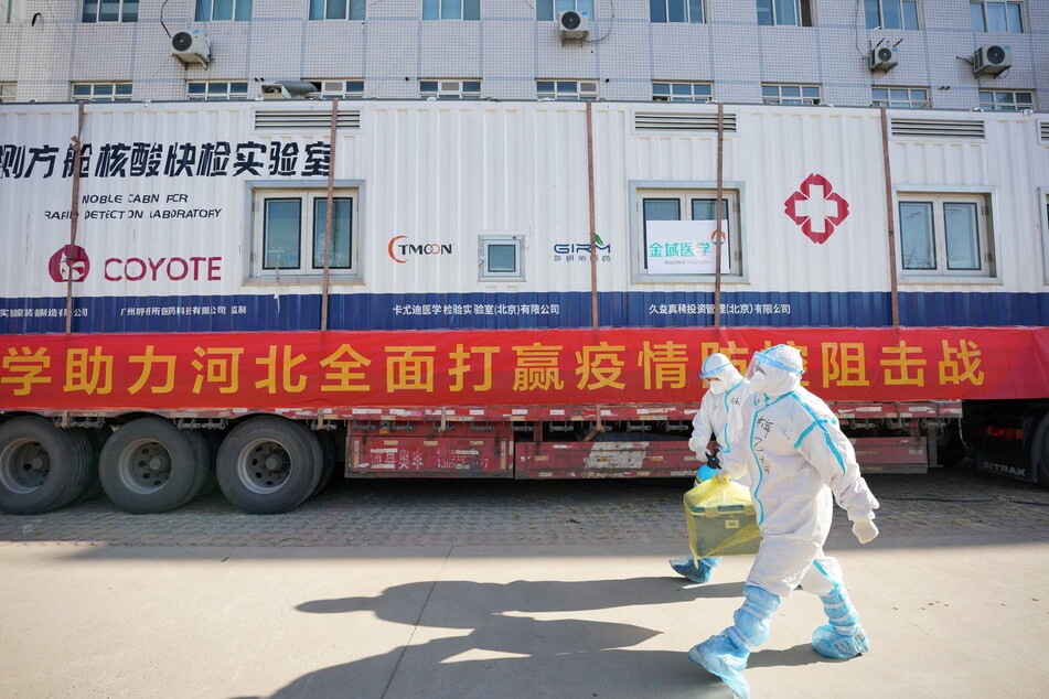 Delivery people pick up and transport patient samples for the Wuhan Leishenshan Hospital.