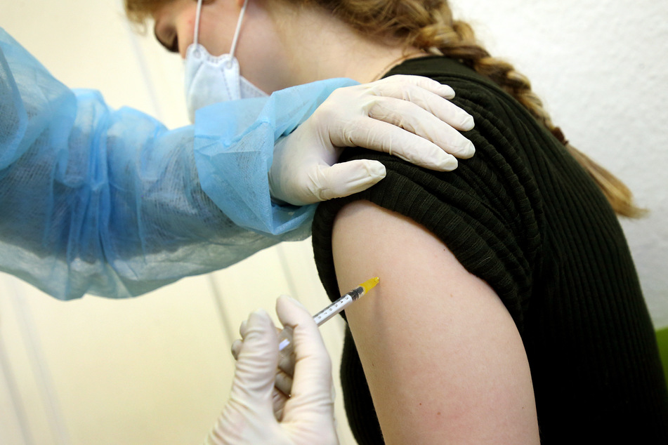 Eine junge Frau bekommt in der Praxis ihrer Hausärztin ihre Booster-Impfung mit dem Comirnaty-Impfstoff des Herstellers Biontech/Pfizer verabreicht.