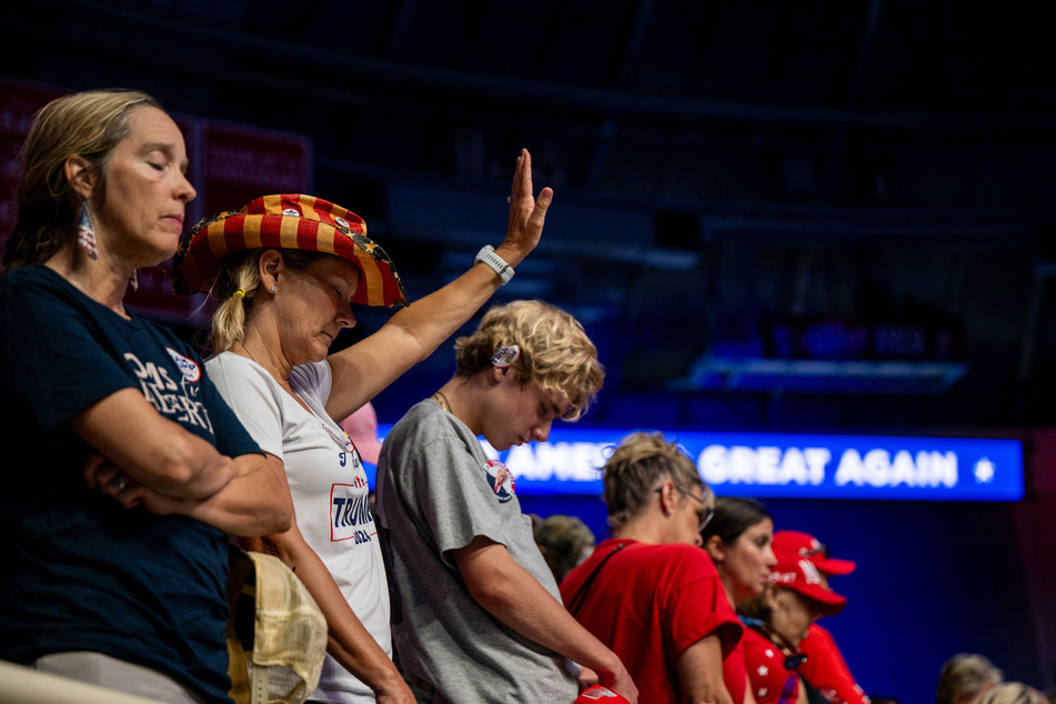 Supporters of Republican Presidential nominee former President Donald Trump pray together ahead of his campaign rally at the Bojangles Coliseum on Wednesday in Charlotte, North Carolina.