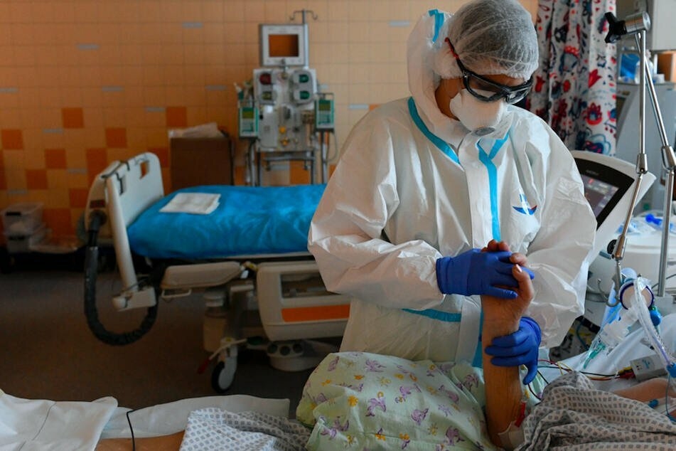 Ein Sanitäter in Schutzkleidung behandelt einen Covid-19-Patienten auf der Intensivstation des Allgemeinen Universitätsklinikums in Prag.