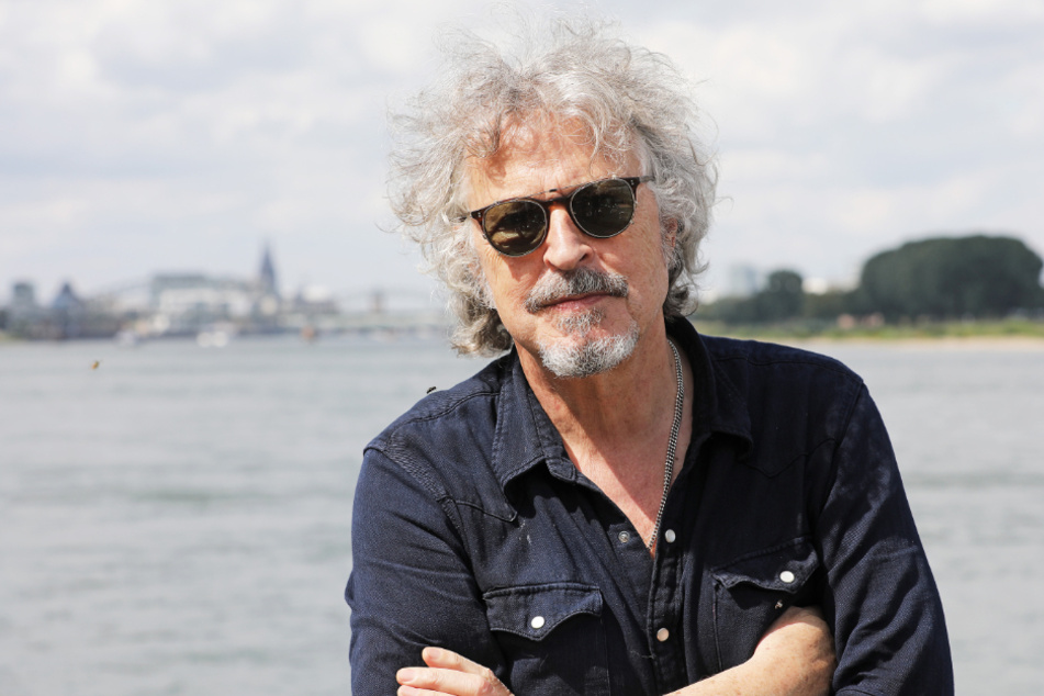 Der Musiker und Sänger Wolfgang Niedecken steht am Rhein.