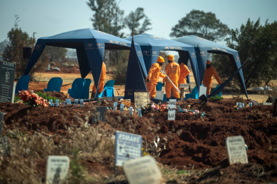 Südafrika, Johannesburg: Arbeiter bereiten eine Beerdigung auf dem Olifantsveil-Friedhof außerhalb der Stadt vor. In Südafrika, als einem der fünf am schwersten von der Corona-Pandemie betroffenen Länder weltweit, hat die Häufigkeit von Bestattungen während der Pandemie stark zugenommen.