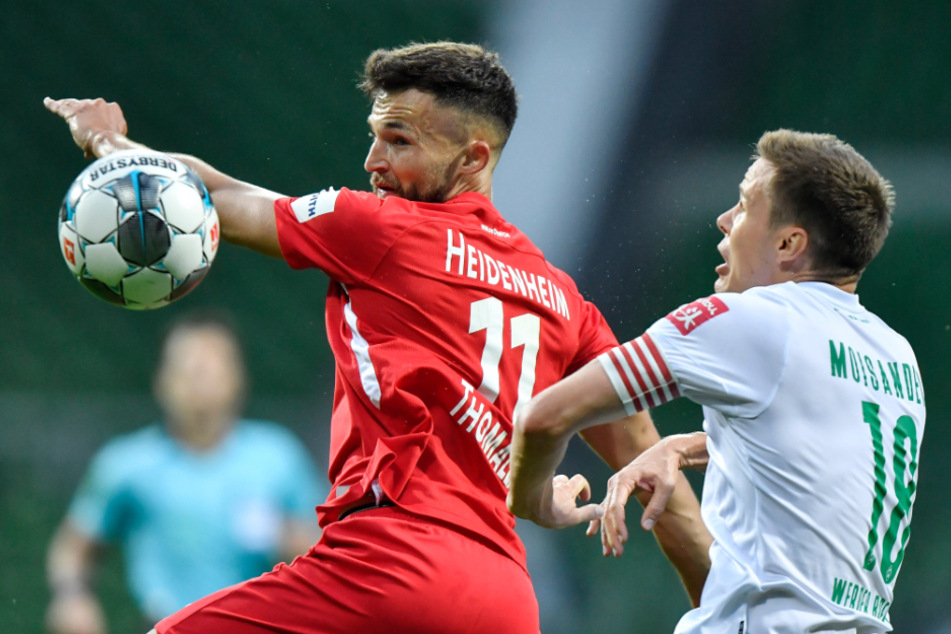 Heidenheims Denis Thomalla (l) und Bremens Niklas Moisander kämpfen um den Ball.