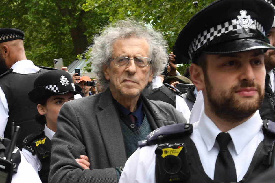Piers Corbyn (M), Astrophysiker und Bruder des ehemaligen Labour-Vorsitzenden J. Corbyn, wird bei einer Demonstration von Polizisten abgeführt.