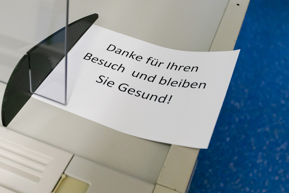 Ein Zettel mit der Aufschrift "Danke für Ihren Besuch und bleiben Sie gesund" liegt auf einem Tisch im Impfzentrum in Gettorf im Kreis Rendsburg-Eckernförde.