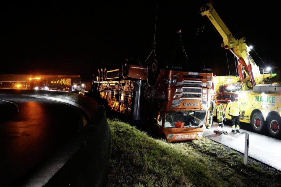 Ein Kran ist dabei, den umgekippten Lastwagen aus der Böschung zu hieven.