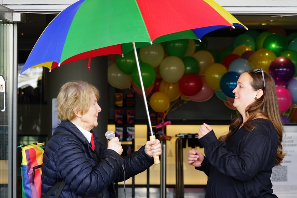 Kinderbuchautorin Ursel Scheffler (85) überreicht Sonja Plesse (l.), stellvertretende Theaterleiterin des Theaters im Hafen, als symbolischer Geste für die übernommene Schirmherrschaft einen bunten Regenschirm.