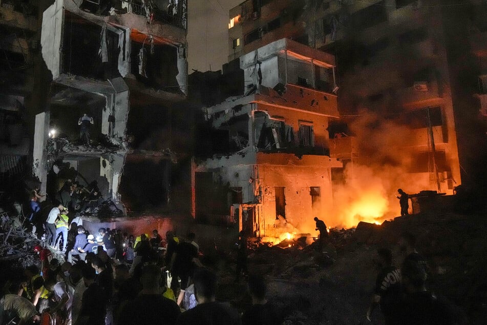 Menschen versammeln sich in Beirut vor zerstörten Gebäuden, die von einem israelischen Luftangriff getroffen wurden.