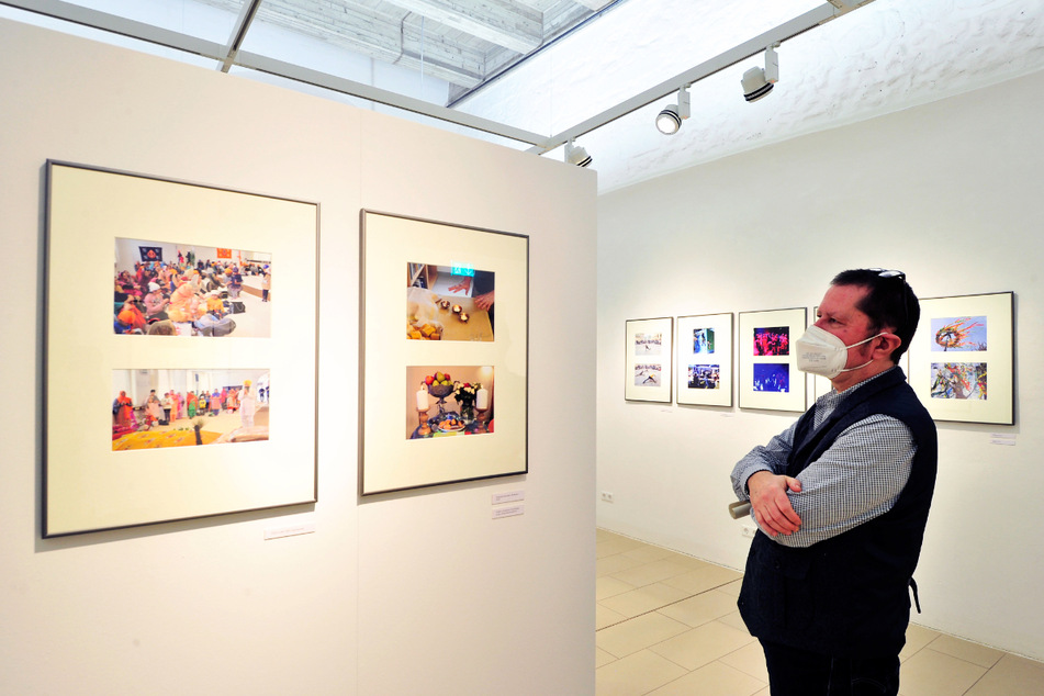 Museumsleiter Uwe Fiedler (60) schaut interessiert auf Fotos der Ausstellung.