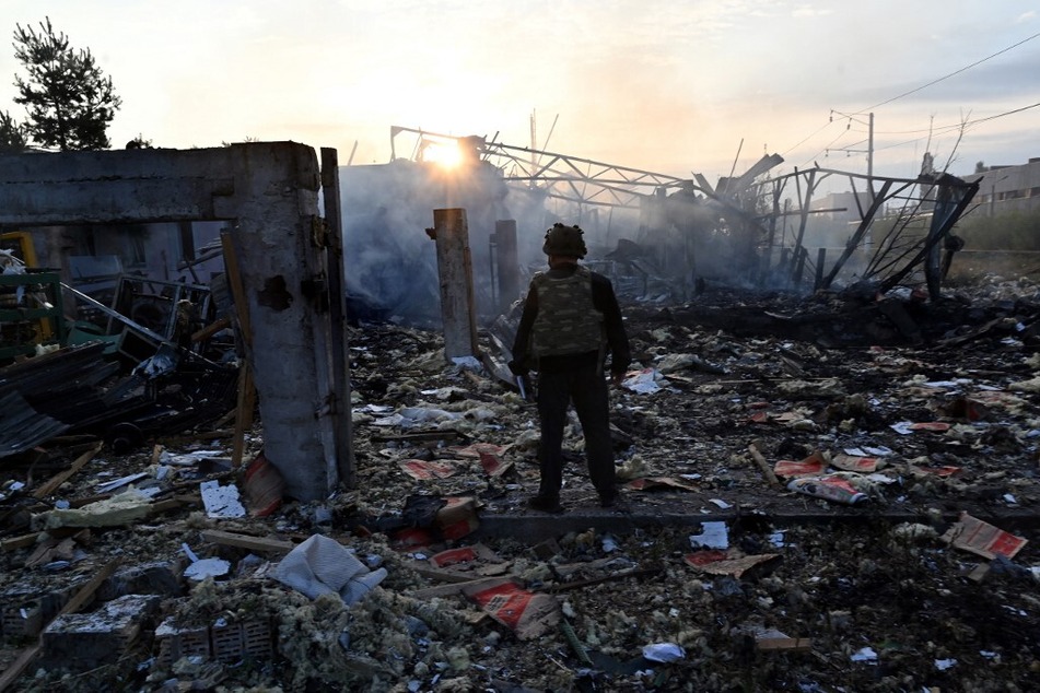 Police experts look at damages on an industrial area in the Ukrainian capital of Kyiv after a massive overnight missile attack on September 21, 2023.
