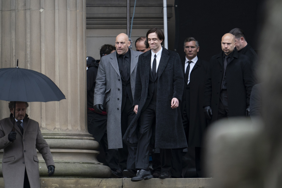 Robert Pattinson (Mitte), Schauspieler aus Großbritannien, steht bei den Dreharbeiten zum Film "The Batman" vor der St. George's Hall.