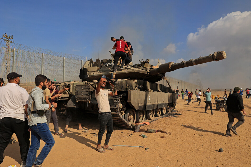 Palästinenser posieren mit einem erbeuteten israelischen Merkava-Panzer an der Grenze zum Gaza-Streifen.