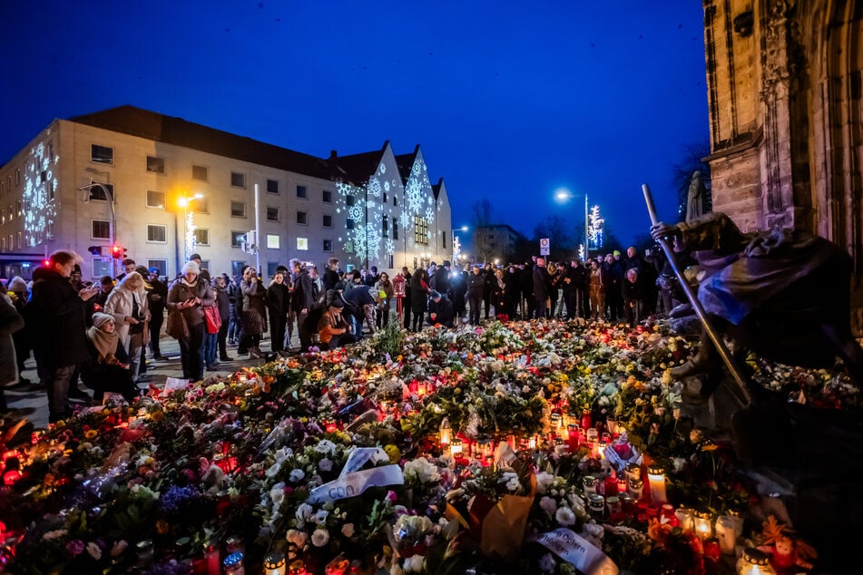 Zahlreiche Blumen und Kerzen liegen nahe dem Magdeburger Weihnachtsmarkt in Gedenken an die Opfer.