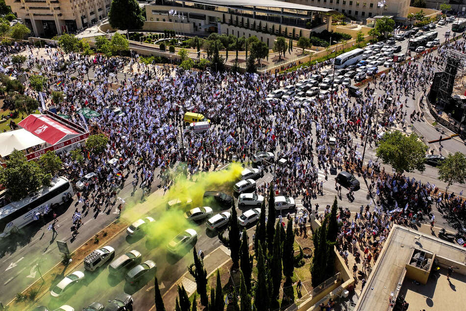An aerial view shows a yellow flare among protesters as they demonstrate against the overhaul of Israel's judicial system.