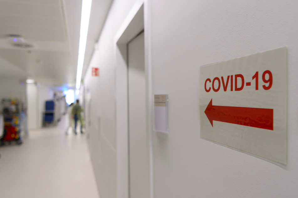 Ein Richtungspfeil zum "Covid-19" Bereich klebt vor einer Intensivstation an der Wand.
