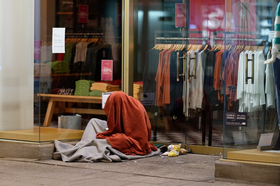 Ein Obdachloser in der Kölner Innenstadt ist bei Eiseskälte in dünne Decken gehüllt.