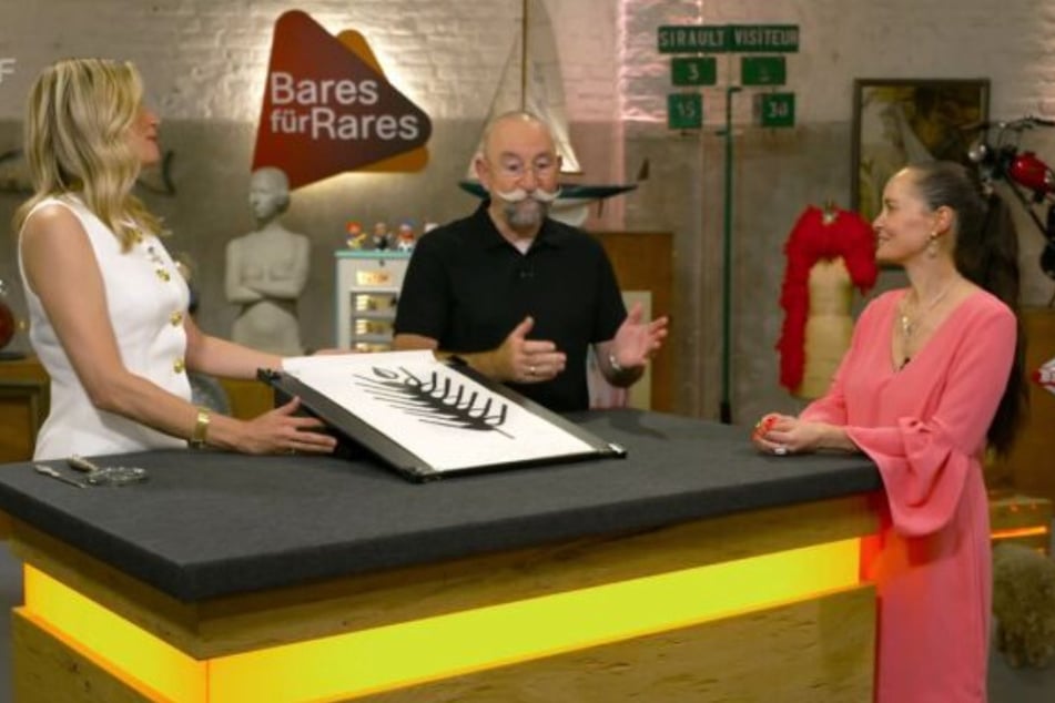 "Bares für Rares"-Kandidatin Eva-Maria (r.) aus Odenthal möchte in der ZDF-Trödelshow eine Grafik von Heinz Mack verkaufen - für 800 Euro.