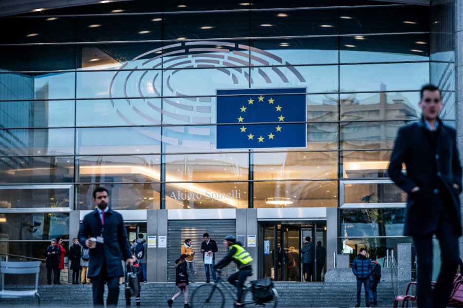 Belgien, Brüssel: Passanten gehen vor dem Europäischen Parlament über die Straße.
