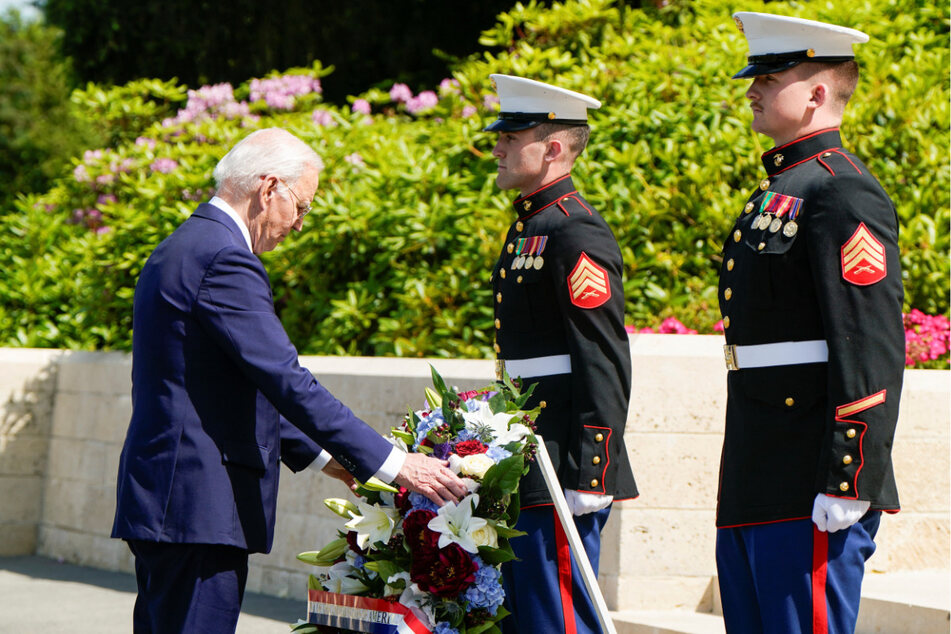 President Joe Biden touches a wreath at a ceremony at Aisne-Marne American Cemetery in Belleau, France.