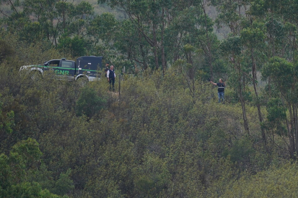 Polizisten stehen zwischen den Bäumen am Arade-Stausee, während die Suche im Rahmen der Ermittlungen zum Verschwinden von Madeleine (Maddie) McCann fortgesetzt wird.