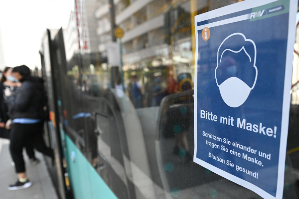 Ein Hinweiszettel hängt an der Scheibe eines RMV-Busses.