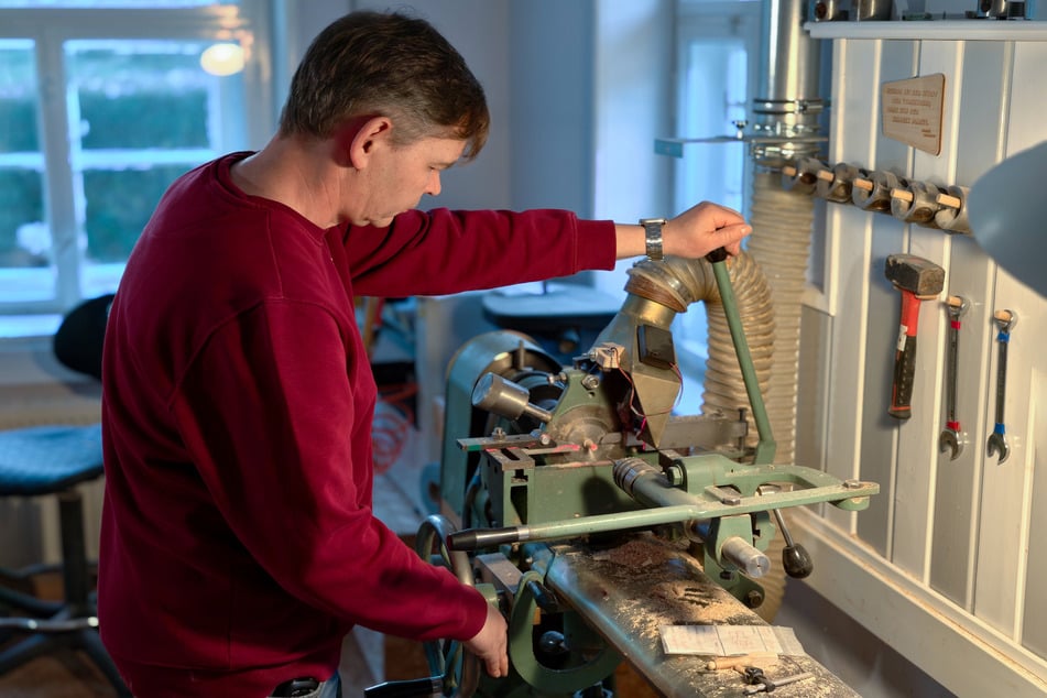 Dirk Hobler (53) steht in der Werkstatt an einer Drechselmaschine.