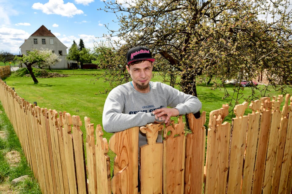 Rocco Häschke (35) mit seinem besonderen Schnitzzaun.