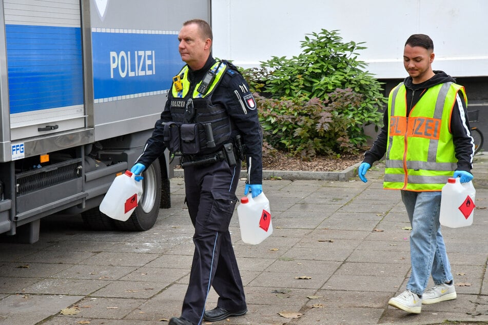 Polizisten bringen Kanister mit unbekannten Substanzen zum Experten-Team.