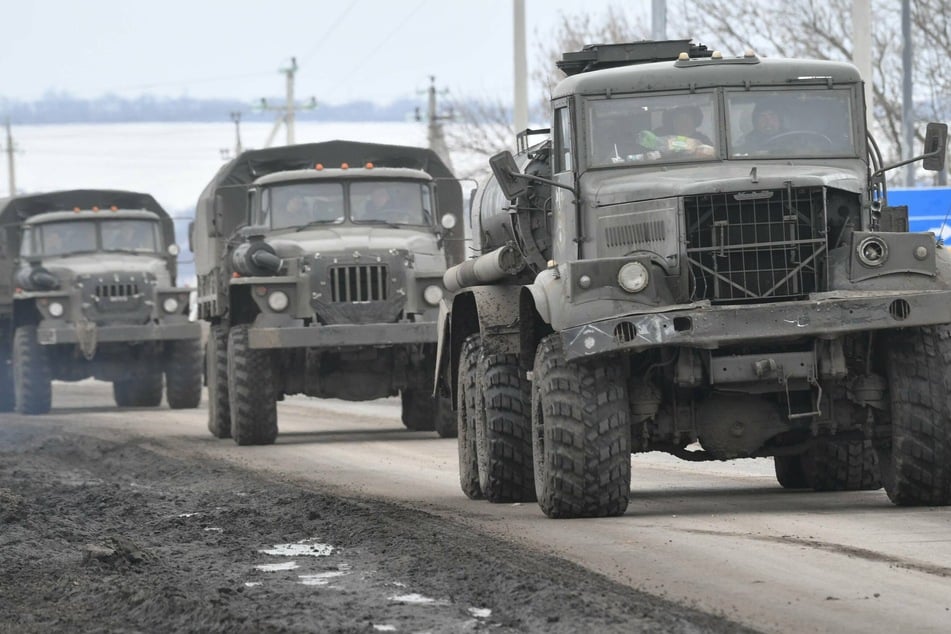 Russian military trucks drive along a road near the border between Russia and Ukraine in the Belgorod region.