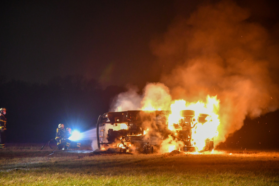 Das Auto kippte auf die Seite und fing Flammen. Feuerwehrleute löschten es.
