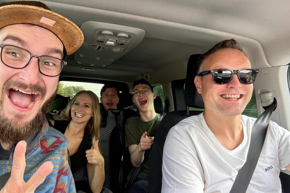 Die Band "Luxus Loft" grüßt aus dem Bandbus während der Fahrt gen Schweiz.