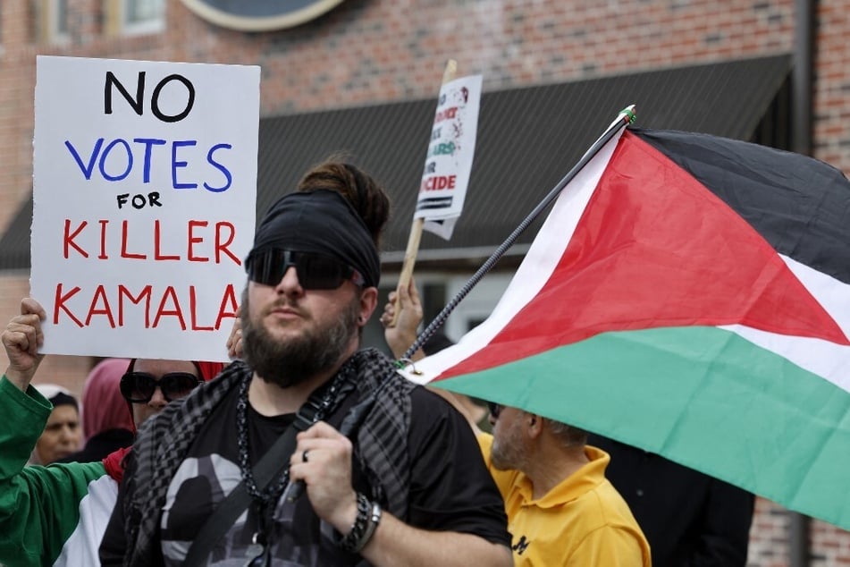 Demonstrators raise signs reading "No Votes for Killer Kamala" during a Gaza solidarity protest outside the Arab American National Museum in Dearborn, Michigan.