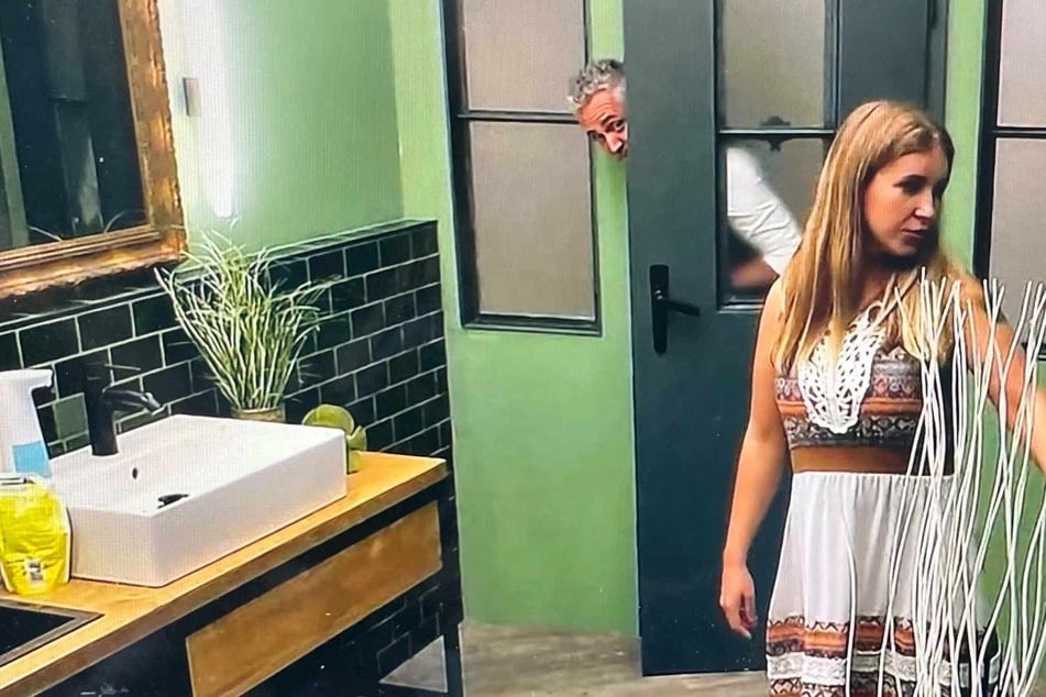 Sabrina (34) ahnt nichts davon, dass Roland Trettl (54) sie heimlich auf der Damentoilette beobachtet.
