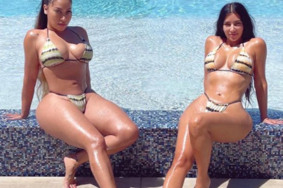 Kim Kardashian (r.) and Lala Anthony show off their curves in revealing bikinis while posing near an infinity pool.