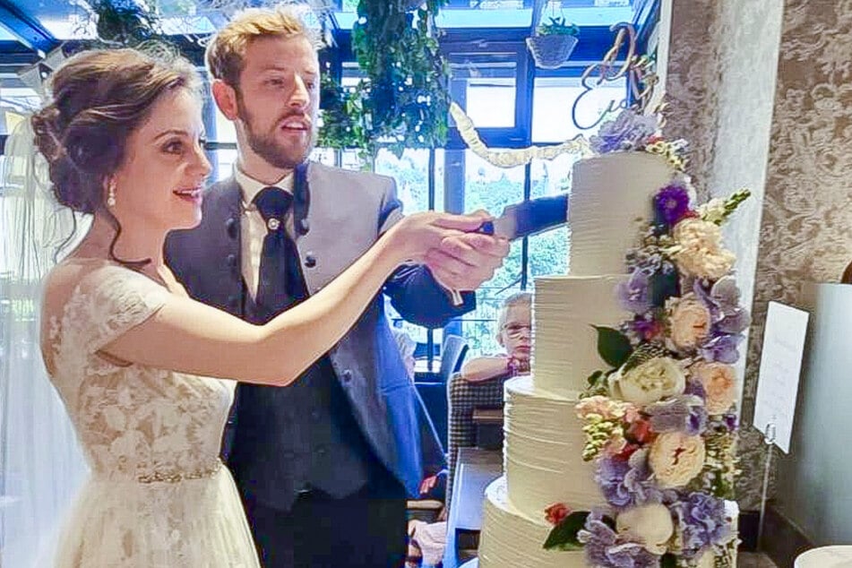 Die Brautleute schneiden ihre vierstöckige Hochzeitstorte im Café Toscana an.