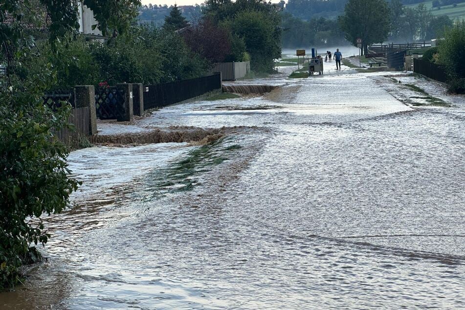 Eine Straße im mittelfränkischen Niederkofen steht komplett unter Wasser.