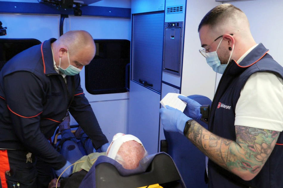 René Lohse (44, l.) und Colin Struthoff (28, r.) kümmern sich um einen 94-jährigen Mann.