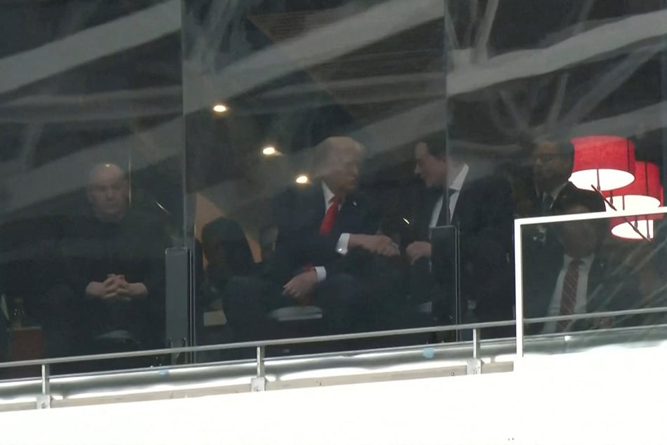 President Donald Trump and Tesla CEO Elon Musk shake hands in a skybox at State Farm Stadium during the memorial service for Charlie Kirk on September 21, 2025.