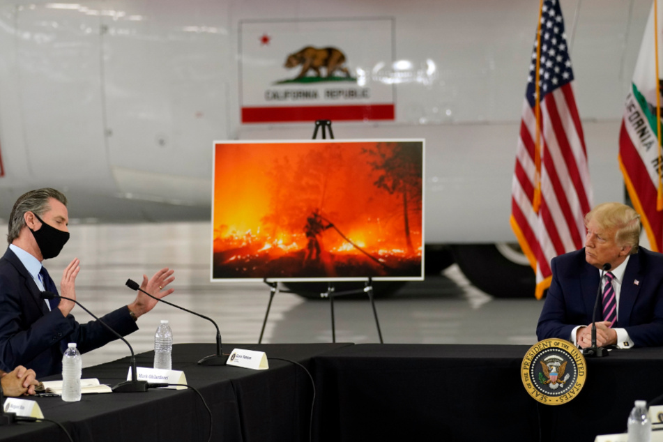 Donald Trump hört zu, als der kalifornische Gouverneur Gavin Newsom während eines Gesprächs auf dem McClellan-Flughafen von Sacramento über die Waldbrände im Westen spricht.