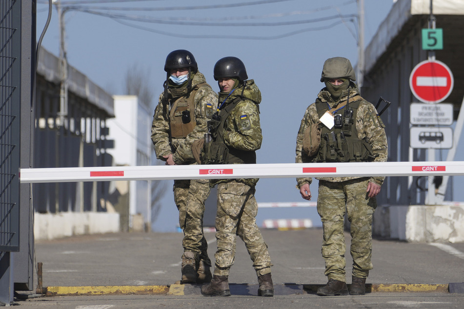 Ukrainische Grenzbeamte stehen an einem Kontrollpunkt.