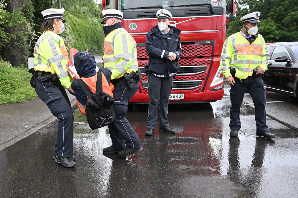 Polizisten entfernen einen Aktivisten der "Letzten Generation", der eine Hauptverkehrsstraße in Stuttgart blockierte.