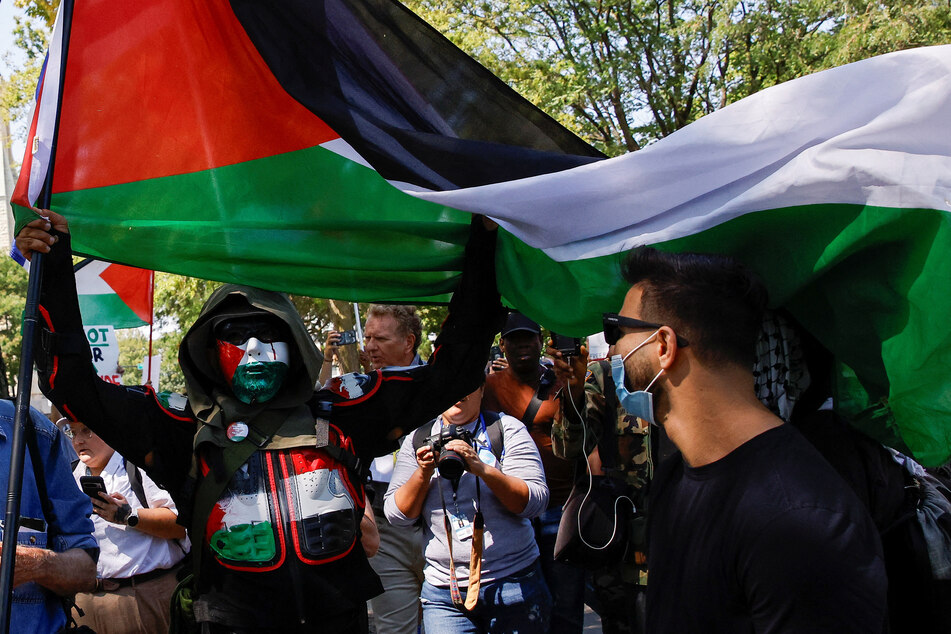 A protester raises a Palestinian flag as demonstrators rally on the sidelines of the Democratic National Convention in Chicago, Illinois.