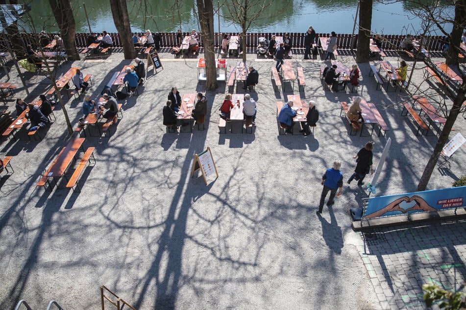 In Tübingen sitzen Menschen bei gutem Wetter in einem geöffneten Biergarten. Die Stadt praktiziert ein eigenes Modellprojekt für kontrollierte Lockerungen mittels Schnelltests.